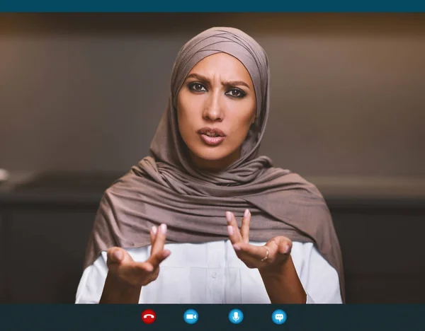 Serious Arab Lady Talking To Camera Making Video Call Indoor