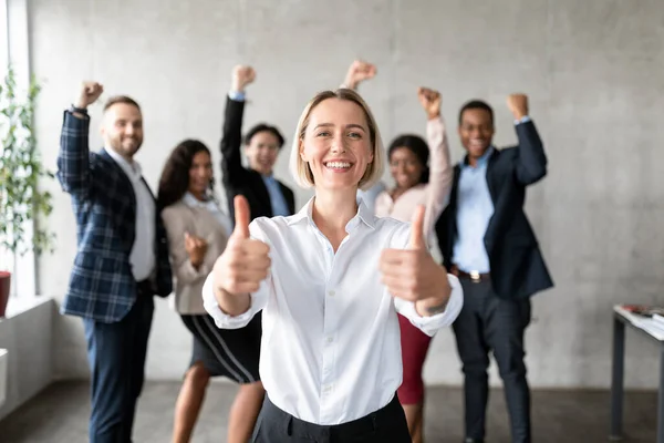 Businesswoman Gesturing Thumbs-Up Standing With Joyful Employees Team In Office — Stock Photo, Image