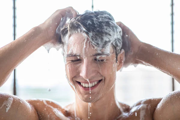 Handsome young male model washing hair with shampoo — Stock Photo, Image