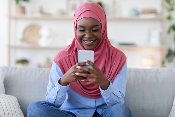 Jóvenes Musulmanes Negros Navegando por las Redes Sociales en Smartphone, Relajándose en Casa —  Fotos de Stock