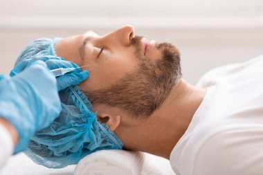 Orta yaşlı bir adam estetik kliniğe gidip güzellik iğneleri yaptırıyor.