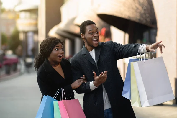 Verrast geschokt en opgewonden millennial Afrikaanse Amerikaanse man en vrouw tonen bij etalage — Stockfoto