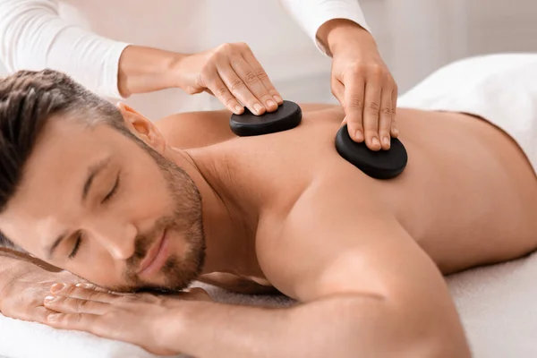 Close-up van de man met hete stenen massage in luxe spa — Stockfoto