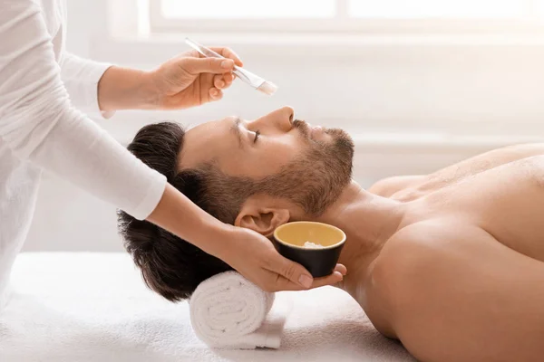 Bonito homem tendo tratamento facial no salão de spa — Fotografia de Stock