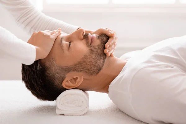 Hombre dormido recibiendo masaje facial curativo en el spa —  Fotos de Stock