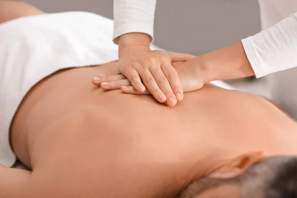 Female therapist massaging unrecognizable man back, pushing on his spine — Stock Photo, Image