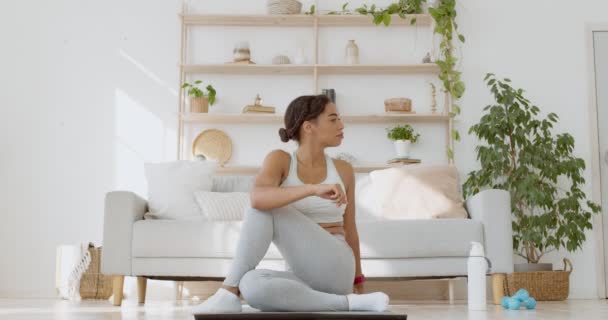 Young african american lady doing stretching practice, sitting on floor at home and twisting body, slow motion — Stock Video