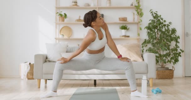 Africano senhora americana praticando agachamento profundo e exercício de alongamento do corpo em casa, câmera lenta — Vídeo de Stock
