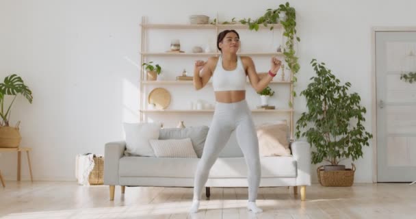 Enérgica dama afroamericana bailando después del entrenamiento de fitness en casa, disfrutando de su estilo de vida, cámara lenta — Vídeos de Stock