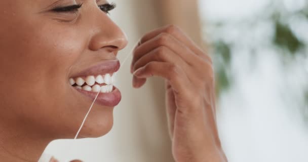 Молодая черная женщина чистит зубы зубной нитью дома, закрывает портрет — стоковое видео