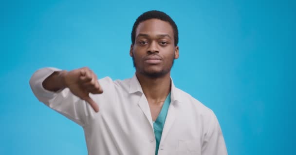 コンセプトが嫌い。スタジオ肖像の負のアフリカ系アメリカ人医師ジェスチャー親指ダウンと揺れ頭 — ストック動画