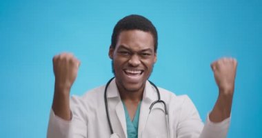 Evet, kazanan jest. Beyaz önlüklü siyahi doktor hastalıklara karşı başarı ve zaferin tadını çıkarıyor.