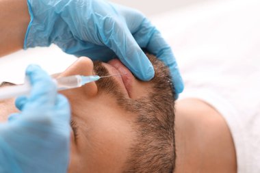 Estetik kliniğinde dudaklarını dolduran tanınmayan bir adam.