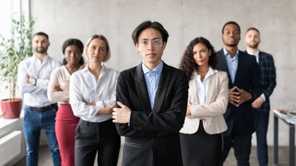 Asiático hombre de negocios posando de pie con su equipo de empleados en la oficina —  Fotos de Stock