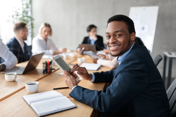 Homme d'affaires africain utilisant une tablette numérique lors d'une réunion d'entreprise au bureau — Photo