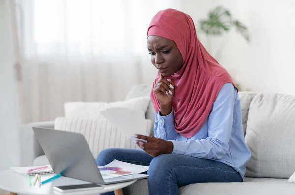 Designer grafico musulmano nero femminile che lavora a casa con campioni e laptop — Foto Stock