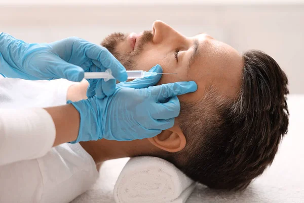 Cosmetólogo haciendo inyecciones de belleza para hombre de mediana edad —  Fotos de Stock