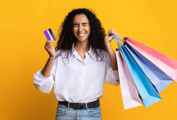 Donna Shopaholic in possesso di carta di credito e un sacco di borse luminose shopping — Foto Stock