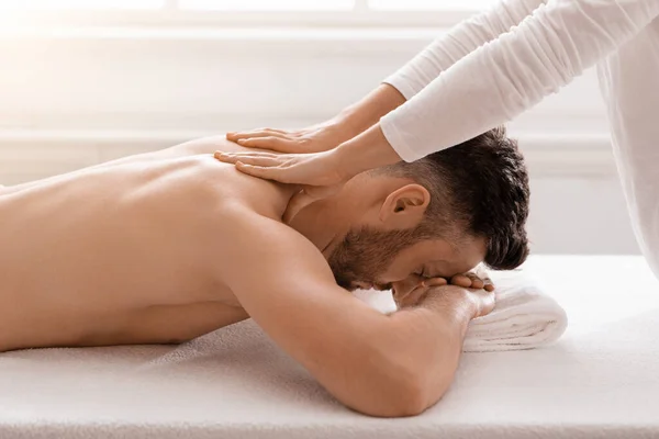 Vista lateral do homem relaxado fazendo massagem corporal no spa — Fotografia de Stock