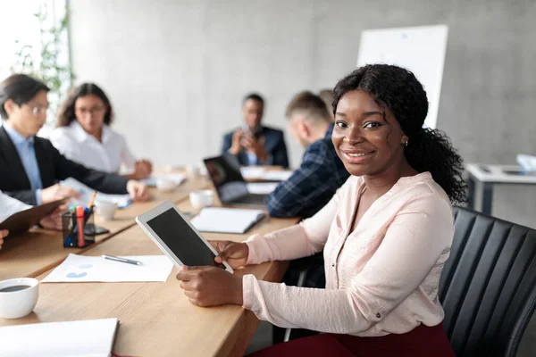 Empresária afro-americana usando tablet em reunião corporativa no escritório — Fotografia de Stock