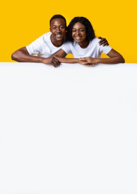 Boş tahtaya yaslanan mutlu Afro-Amerikan çifti