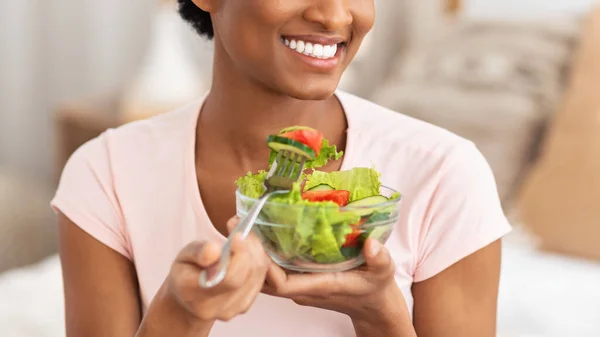 Vue recadrée de jeune dame noire mangeant de la salade de légumes frais à l'intérieur, panorama — Photo