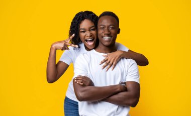 Duygusal siyah kadın gülümseyen erkek arkadaşına sarılıyor.