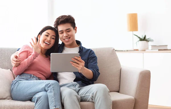 Casal chinês fazendo chamada de vídeo via tablet digital em casa — Fotografia de Stock