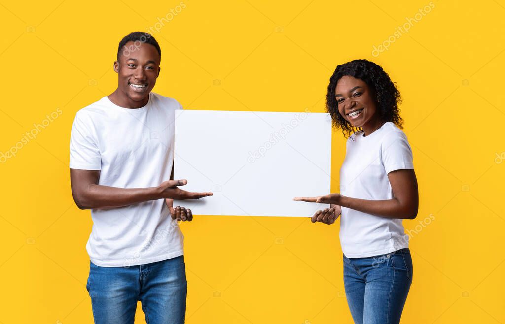 Happy black lovers holding blank board for text