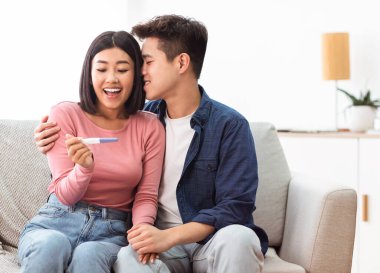 Karı koca hamilelik testinin olumlu sonucunu kutluyor.