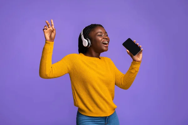 Femme noire s'amuser avec Smartphone et écouteurs sans fil, chanter et danser — Photo