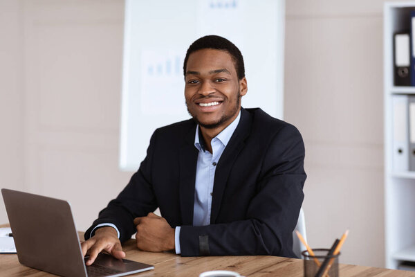 Happy african american businessman looking at camera
