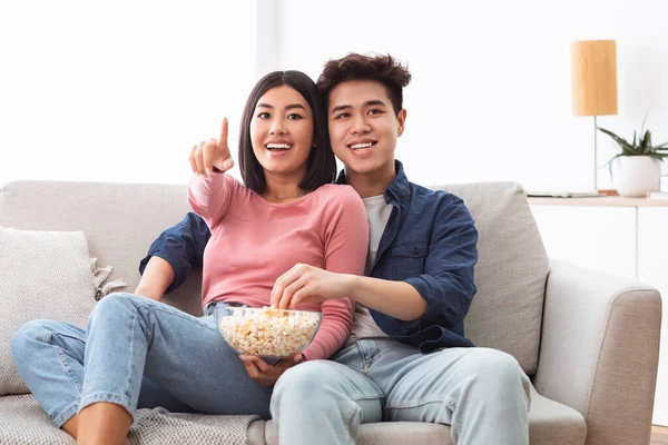 Asijské pár sledování televize a jíst popcorn doma — Stock fotografie