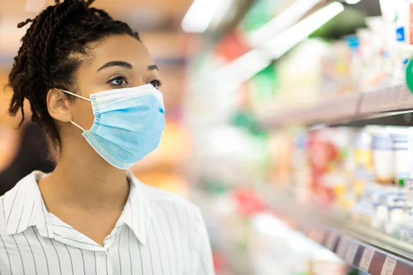 Zwarte vrouw dragen gezicht masker doen kruidenier winkelen in de supermarkt — Stockfoto