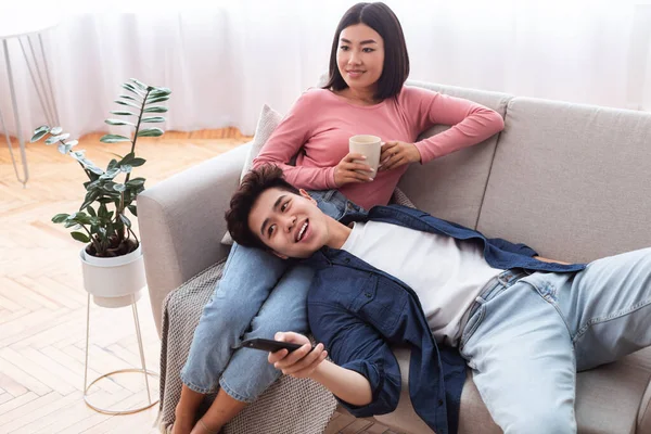 Chineses Cônjuges Relaxante assistindo TV sentado no sofá em casa — Fotografia de Stock