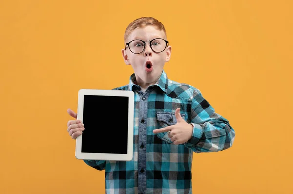 Niesamowity chłopiec wskazujący na pusty cyfrowy ekran tabletu — Zdjęcie stockowe