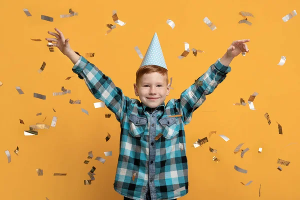 Bonito menino comemorando aniversário sobre o fundo do estúdio amarelo — Fotografia de Stock