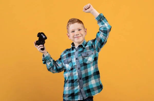 Glücklicher Junge spielt Videospiel mit Joystick und feiert Erfolg — Stockfoto