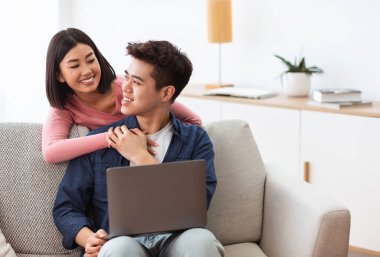 Asyalı Çift Oturma Odasında Oturan İnterneti Tarayarak Dizüstü Bilgisayar Kullanıyor