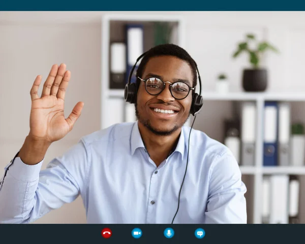 Усміхнений афроамериканський чоловік консультує клієнтів онлайн — стокове фото