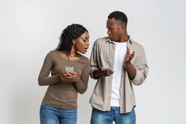 African woman with smartphone spying on her boyfriend — Stock Photo, Image