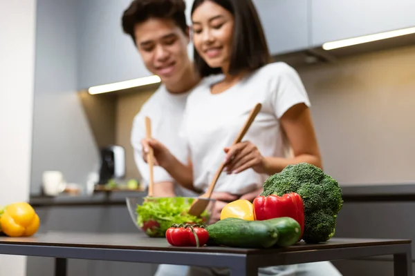 Asian Couple Cooking In Kitchen, Focus On Vegetables On Table — Stock Photo, Image
