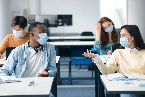 Orvosi maszkot viselő és beszélő nemzetközi diákok — Stock Fotó