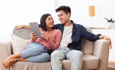 Japon Eşler Tablet Tarama ile İnternet Oturma Kanepesinde Oturuyor