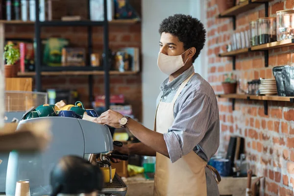 Barmen, kafede modern ekipmanlarla çalışıyor.