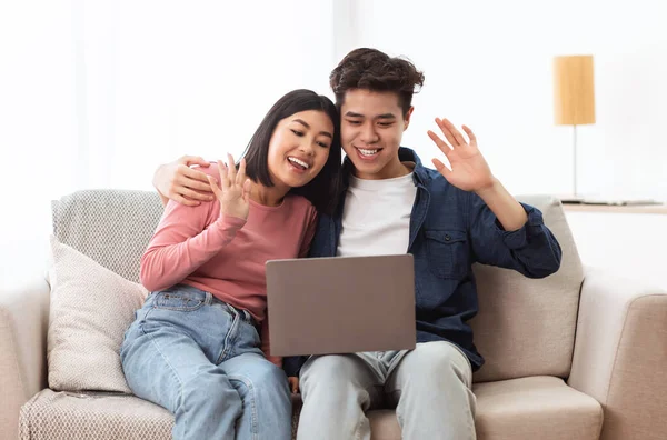 Casal chinês fazendo chamada de vídeo on-line via laptop em casa — Fotografia de Stock