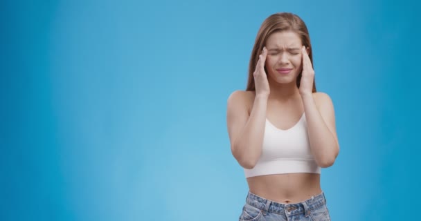 Gestresste jonge vrouw met verschrikkelijke sterke hoofdpijn concept, masseren tempels, lijden aan migraine — Stockvideo