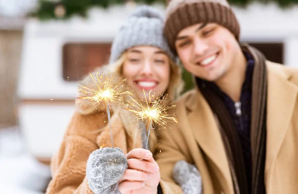 Humor festivo. alegre joven pareja posando con chispas al aire libre en invierno día —  Fotos de Stock