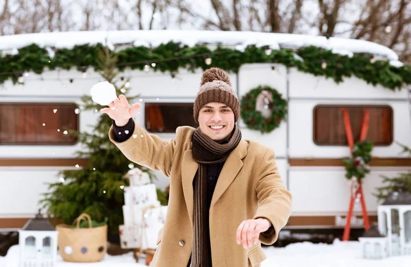 Ragazzo allegro divertirsi all'aperto al campeggio invernale, lanciando palla di neve alla macchina fotografica — Foto Stock