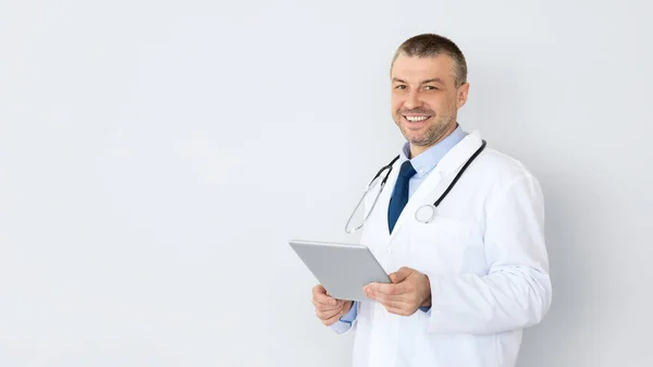 Médico sorridente do sexo masculino segurando tablet digital — Fotografia de Stock